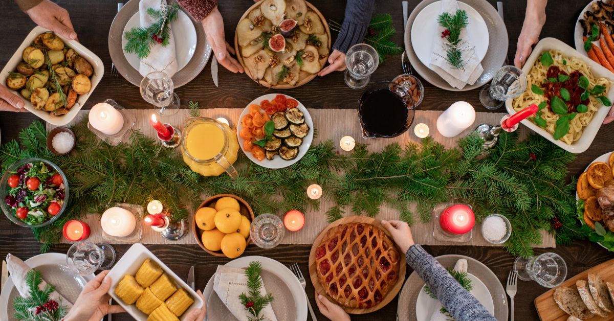 A festive holiday table set with GLP-1-friendly foods, including turkey, vegetables, appetizers, and desserts like pumpkin pie and dark chocolate, ideal for a healthy holiday celebration.