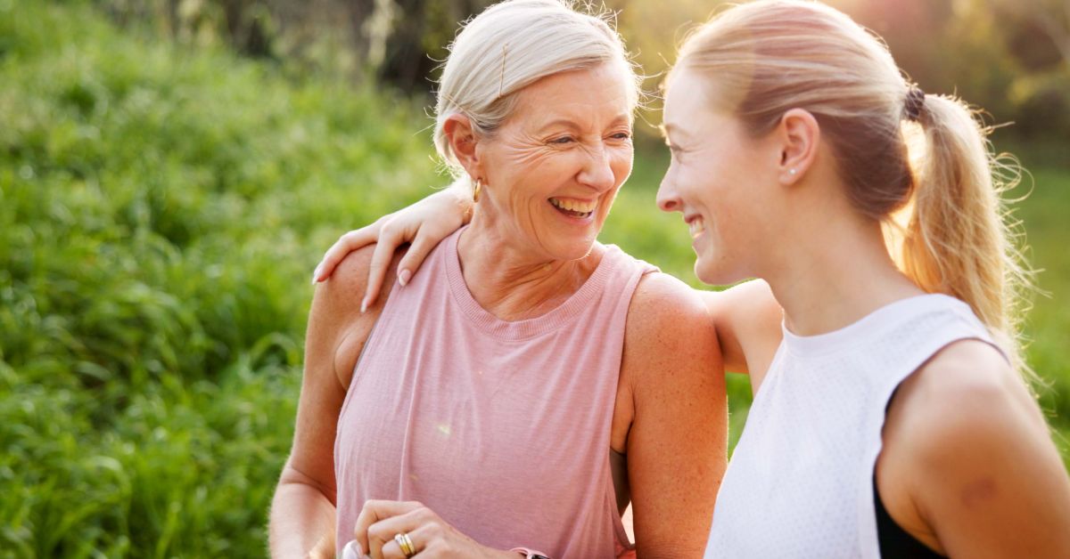 Middle-aged woman smiling with another woman, representing support and connection during perimenopause and menopause.